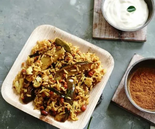 A plate of rice mixed with instant DNachiys Vangi Bath Masala served with curd